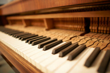 Traditional upright piano and keys close up.