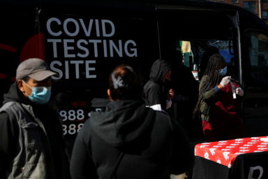A woman administrating nasal swabs for the coronavirus disease (COVID-19) test looks at the swab after taking it from a man at a mobile testing site in the Queens borough of New York