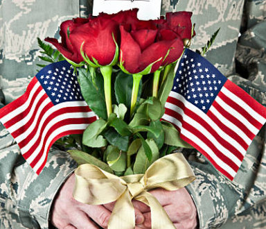 Soldier with rose bouquet and sign that reads, I love you.