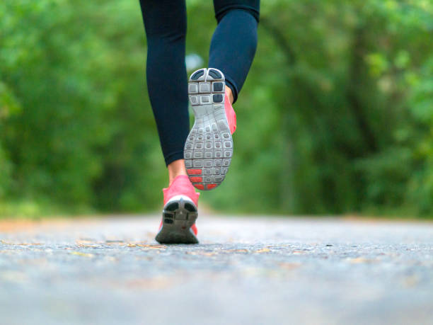 Running woman in the forest. Close-up of sneakers. Healthy lifestyle concept.