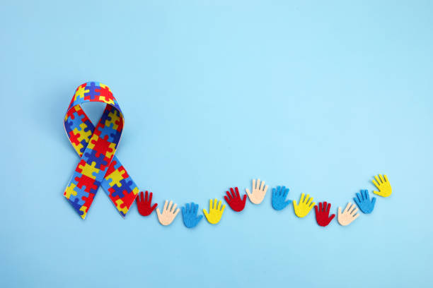 Autism awareness concept with colorful hands on blue background. Top view.