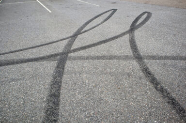 Black tire marks on the parking lot asphalt
