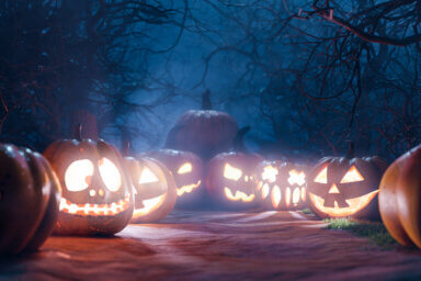 Halloween Backdrop. Halloween Pumpkins In Spooky Forest At Night. Gloomy forest sunset with haunted evil glowing eyes of Jack O’ Lanterns on scary halloween night. 3d rendering