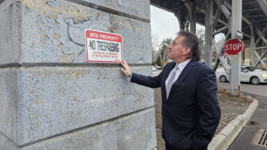 Senator Addabbo views one of the new No Trespassing signs at the Babbage and Bessemer trestle to prohibit illegal parking in the bays.
