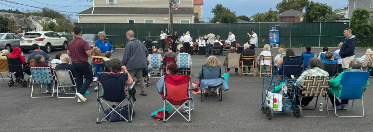 People siting in folding chairs listening to a swing band.