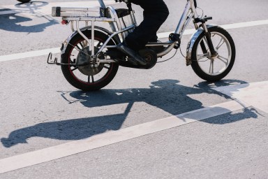 Low Section Unknown Amateur Riding Electric Bicycle In The City