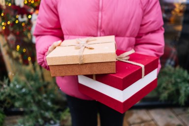 Christmas gifts in the hands of a woman in close-up. Christmas holiday vibe. Christmas lifestyle theme