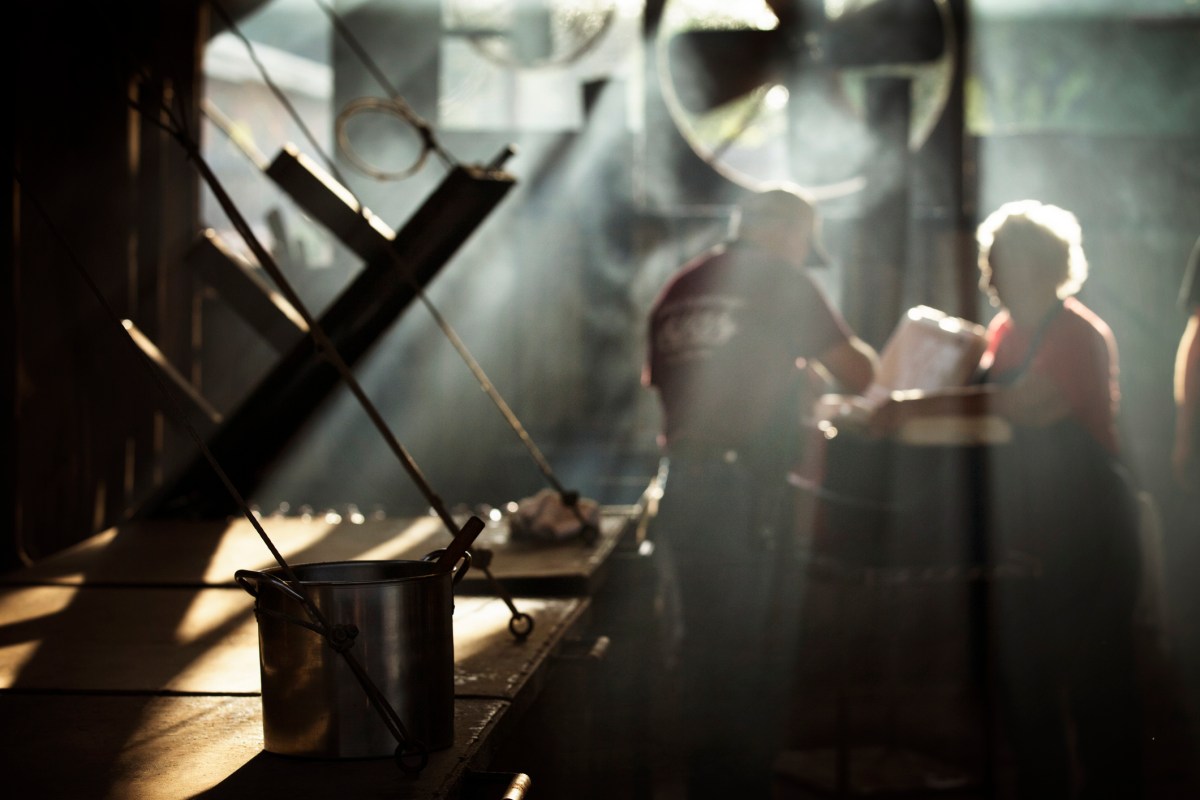 Workers cooking food in kitchen at restaurant