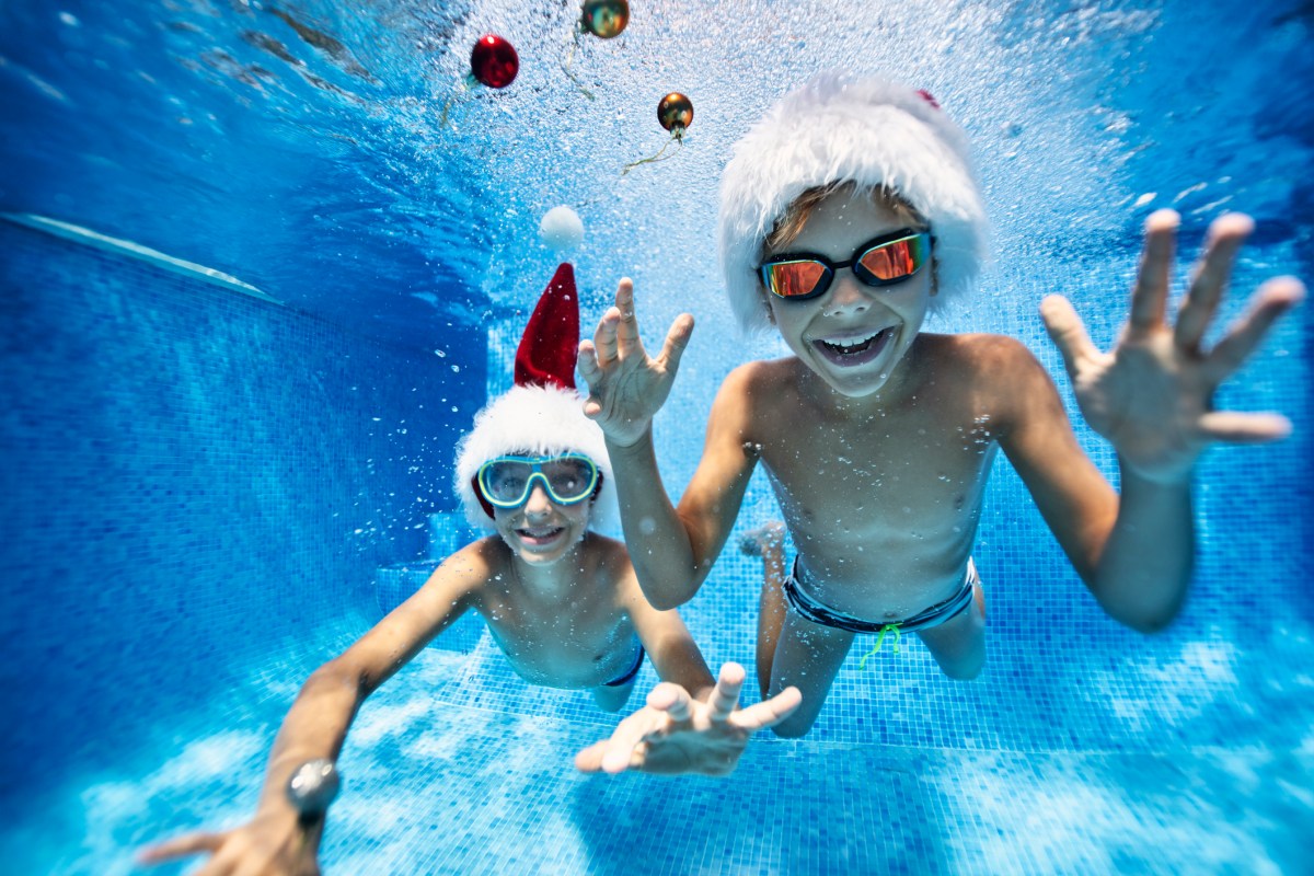 Kids playing with baubles in pool on summer Christmas