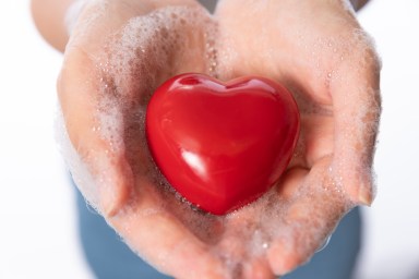 Healthy Woman Holding Heart with soapy hands