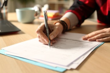 Student girl hand filling out form at night