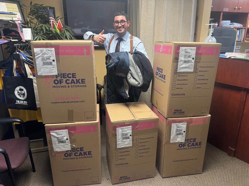 Senator Addabbo’s Chief of Staff, Raimondo Graziano, displays the boxes of coats that will be shipped to NYC Cares.