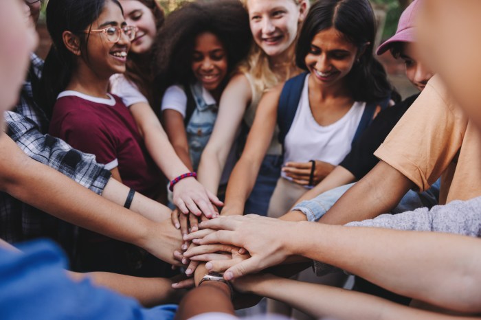 Teenagers putting their hands together in unity