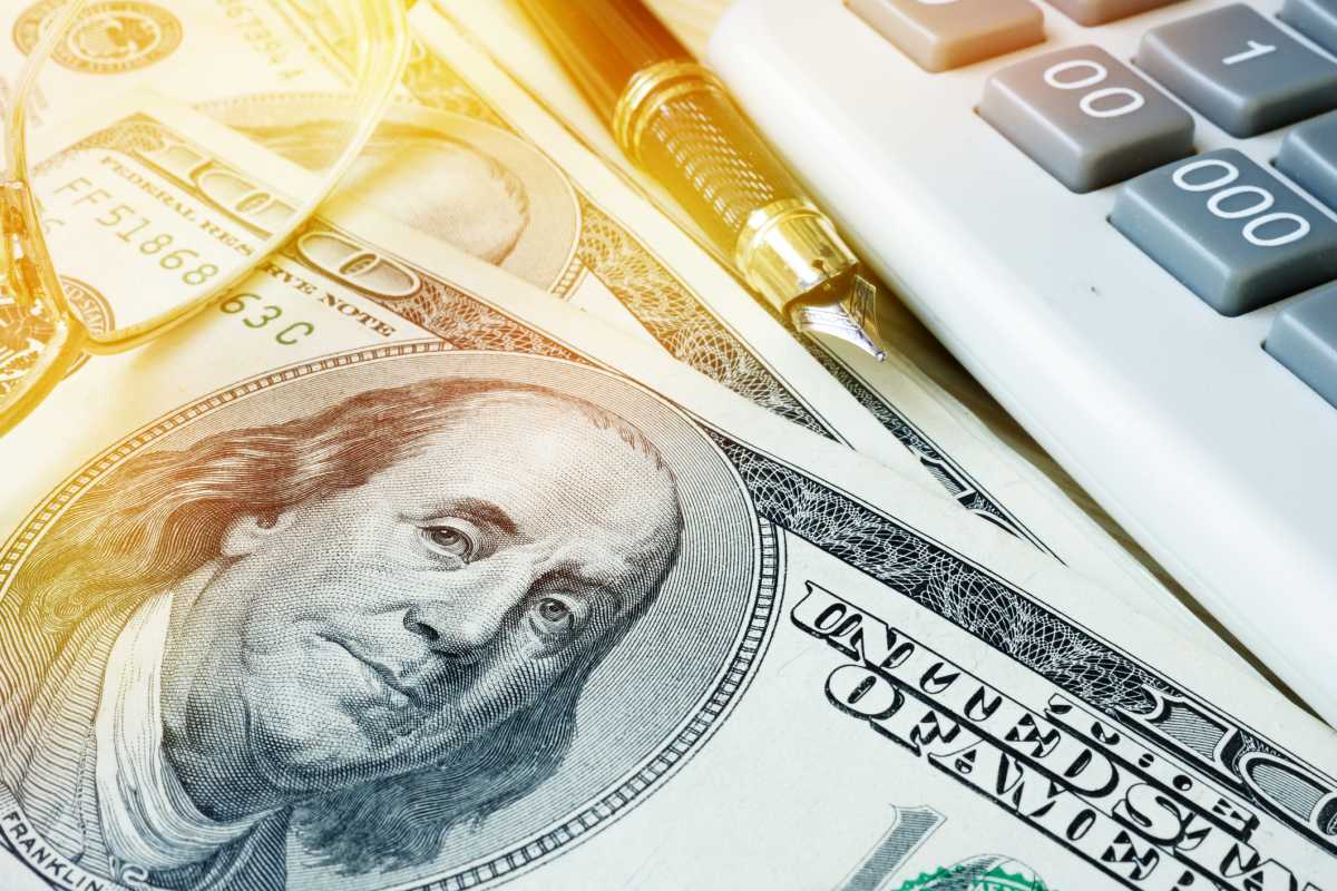 Home finances concept. Savings in dollars, calculator and pen.