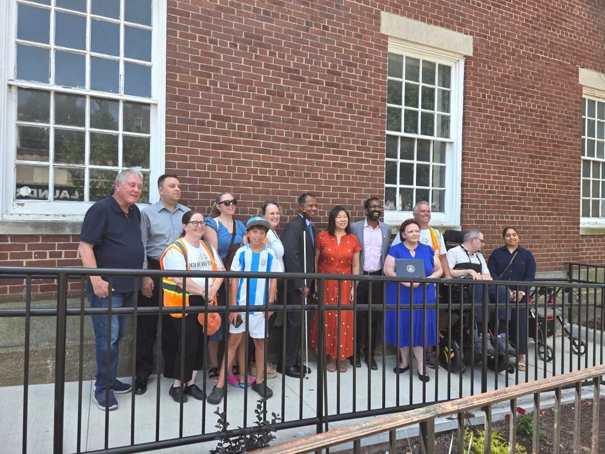 Elected officials and advocates celebrate the new ADA-compliant ramp at the Jackson Heights Post Office. Photo: Shane O'Brien