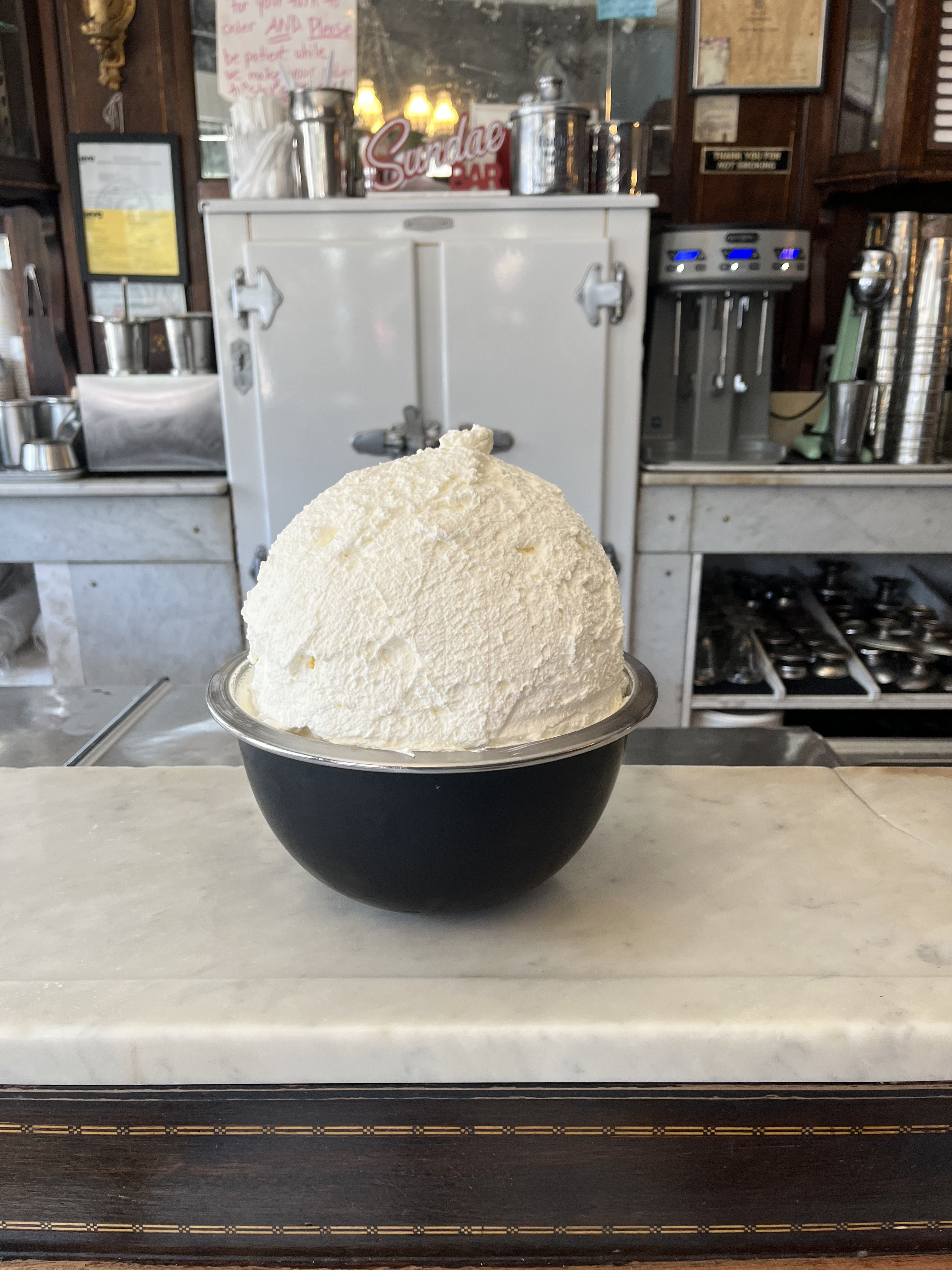 A fresh batch of homemade whipped cream on a marble countertop at Eddie's Sweet Shop in Forest Hills.