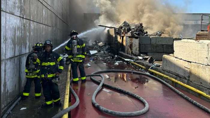 Firefighters battled a stubborn two-alarm fire that broke out in a Maspeth scrapyard on Monday morning.