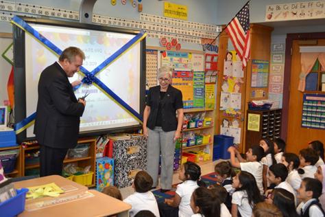 Dromm and PS 69 Principal Martha Vazquez cut the ribbon on one of the school’s new Smart Boards.