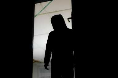 HD stock photography of a burglar entering a house, murderer stalking in the shadows and dark, with knife and a gun, killer silhouette.