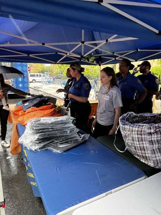 Officers from the NYPD Community Affairs bureau distribute free backpacks at Wednesday's event. Photo courtesy of Projekt NYC.