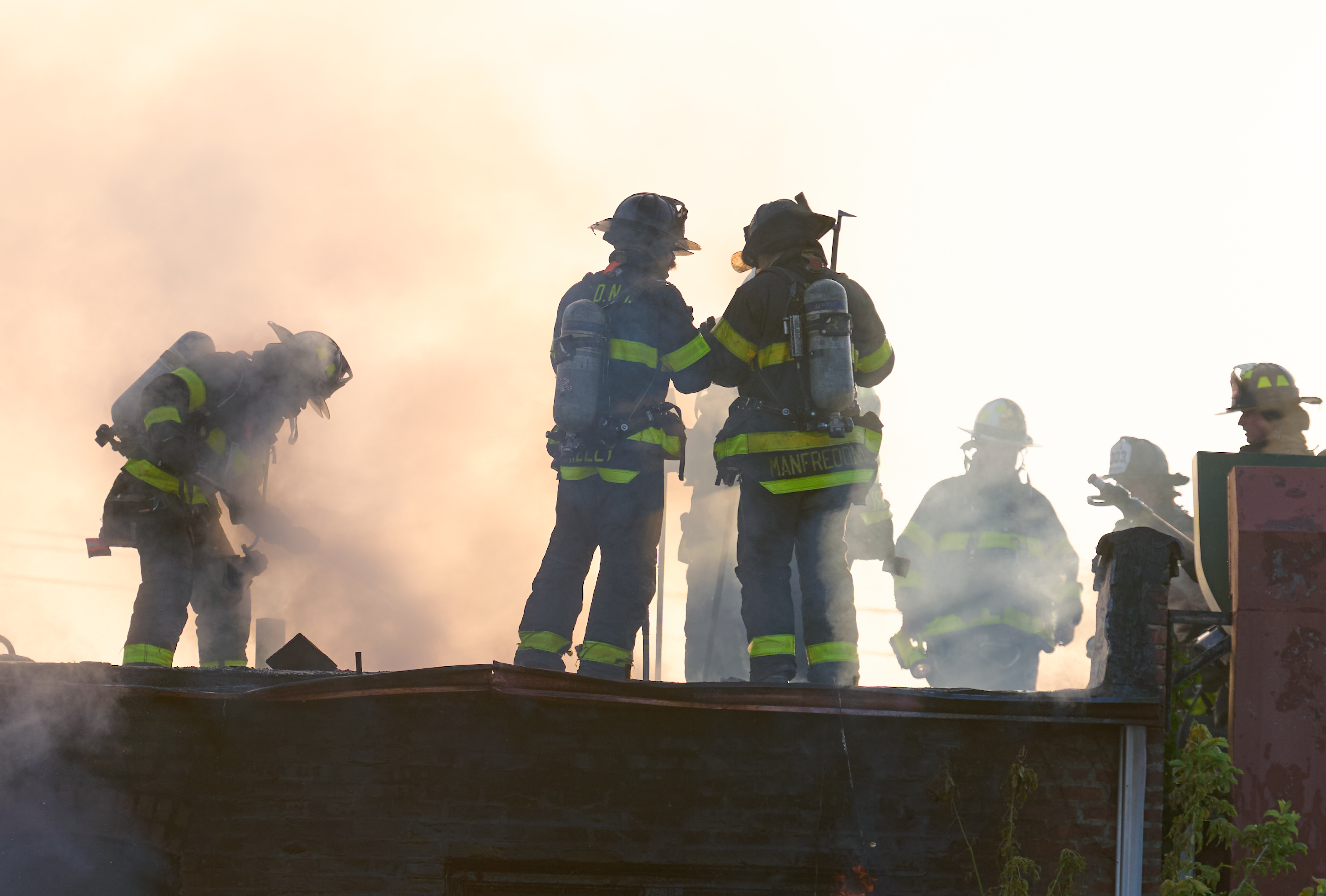 Firefighters work to cut holes in the roof during a four-alarm fire in South Jamaica on Aug. 10.