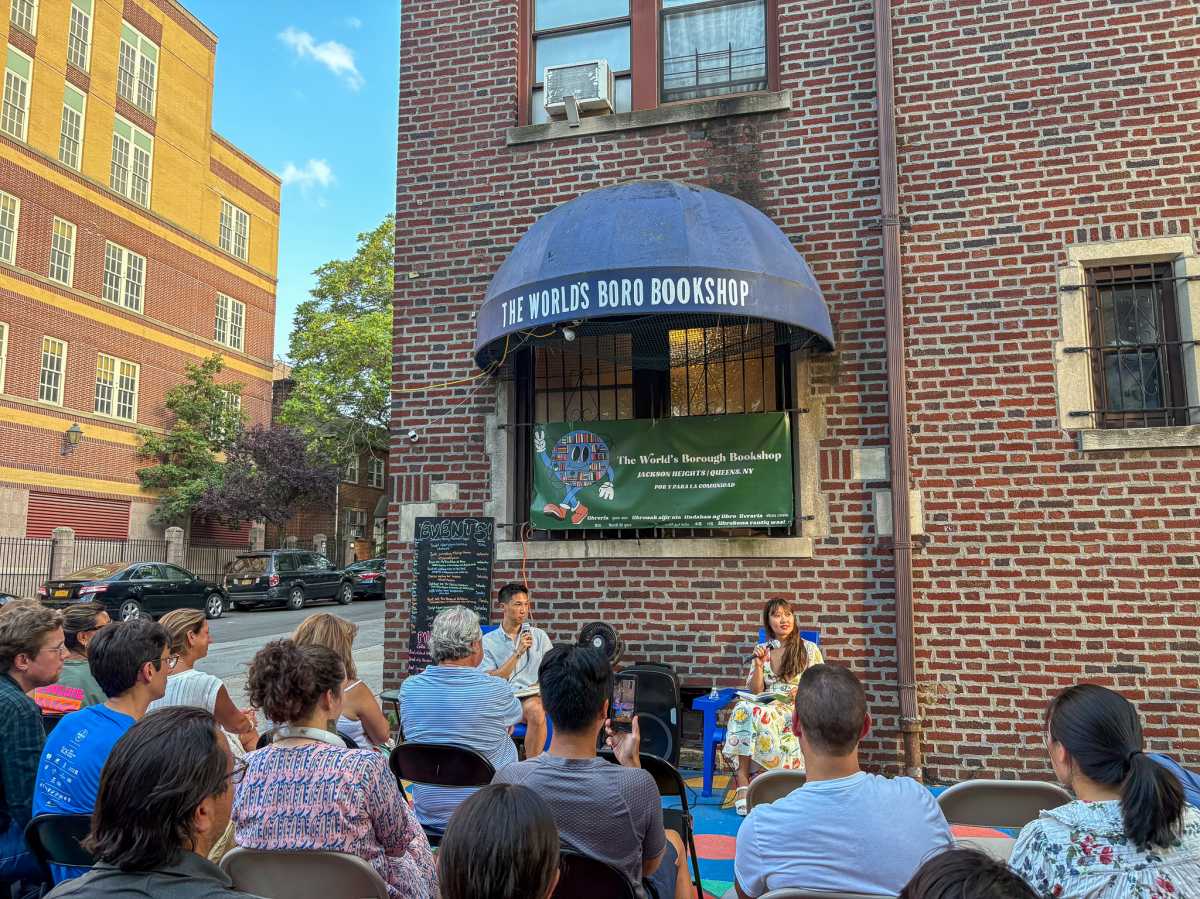 Joseph Lee and Katie Yee talking into their microphones at The World's Borough Bookshop in Jackson Heights.