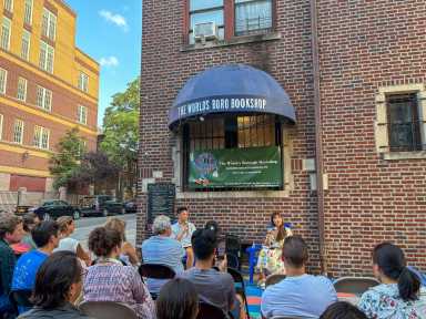 Joseph Lee and Katie Yee talking into their microphones at The World's Borough Bookshop in Jackson Heights.