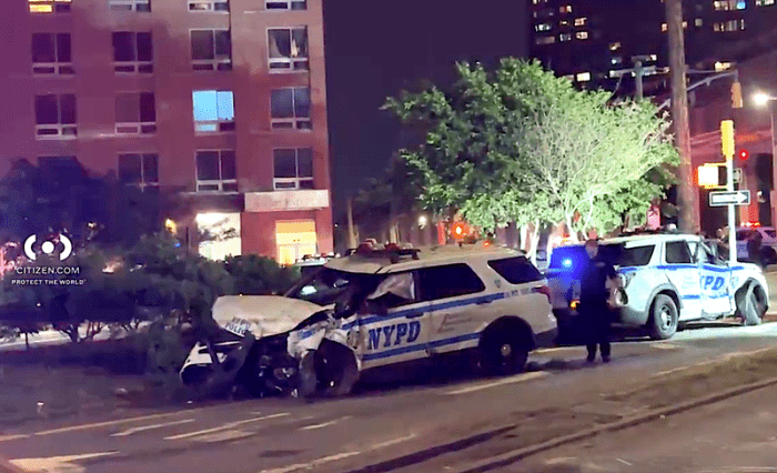 Two NYPD vehicles crashed while racing to a call of shots fired in Far Rockaway on Monday night, and four cops were injured in the head-on collision.