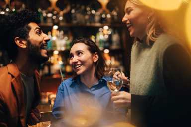 Cheerful male and female friends having fun at bar