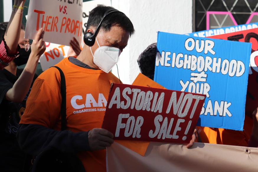 A protestor holding a sign outside the Museum of Moving Image Wednesday (Photo by Michael Dorgan, Queens Post)
