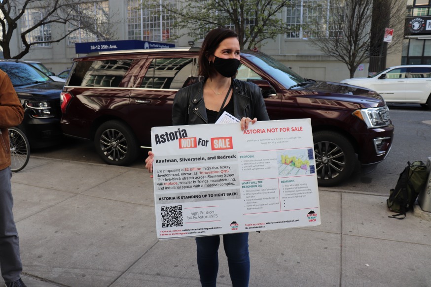Protestor Carolina Korth holding a sign outside the Museum of Moving Image Wednesday (Photo by Michael Dorgan, Queens Post)