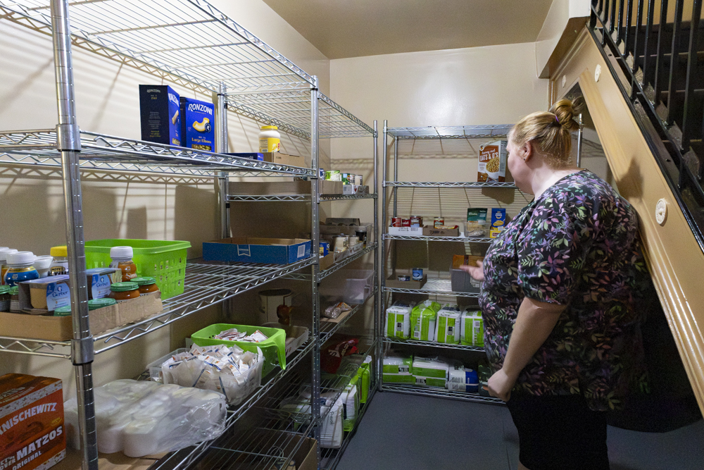 Parish Minister Tara Bear shows the food bank shelves where donations are stored.