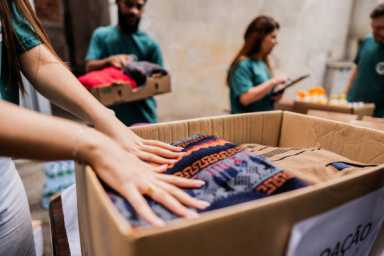 Close-up of volunteers arranging clothes for donation outdoors