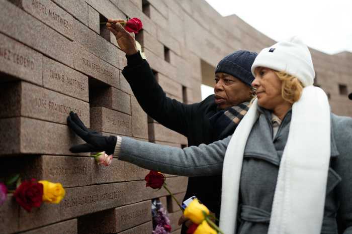 Adams places a flower on a wall dedicated to victims of Flight 587 in Belle Harbor. Photo courtesy of Mayoral Photography Office/Michael Appleton.
