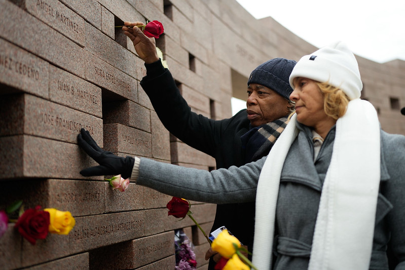 Adams places a flower on a wall dedicated to victims of Flight 587 in Belle Harbor. Photo courtesy of Mayoral Photography Office/Michael Appleton.