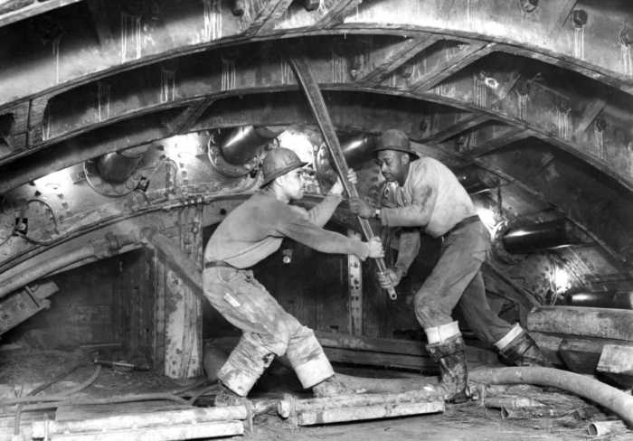 Workers tighten Queens-Midtown Tunnel bolt with 5' ratchet wrench in north tunnel, Queens. February 26, 1939. Photo by Somach Photo Service.