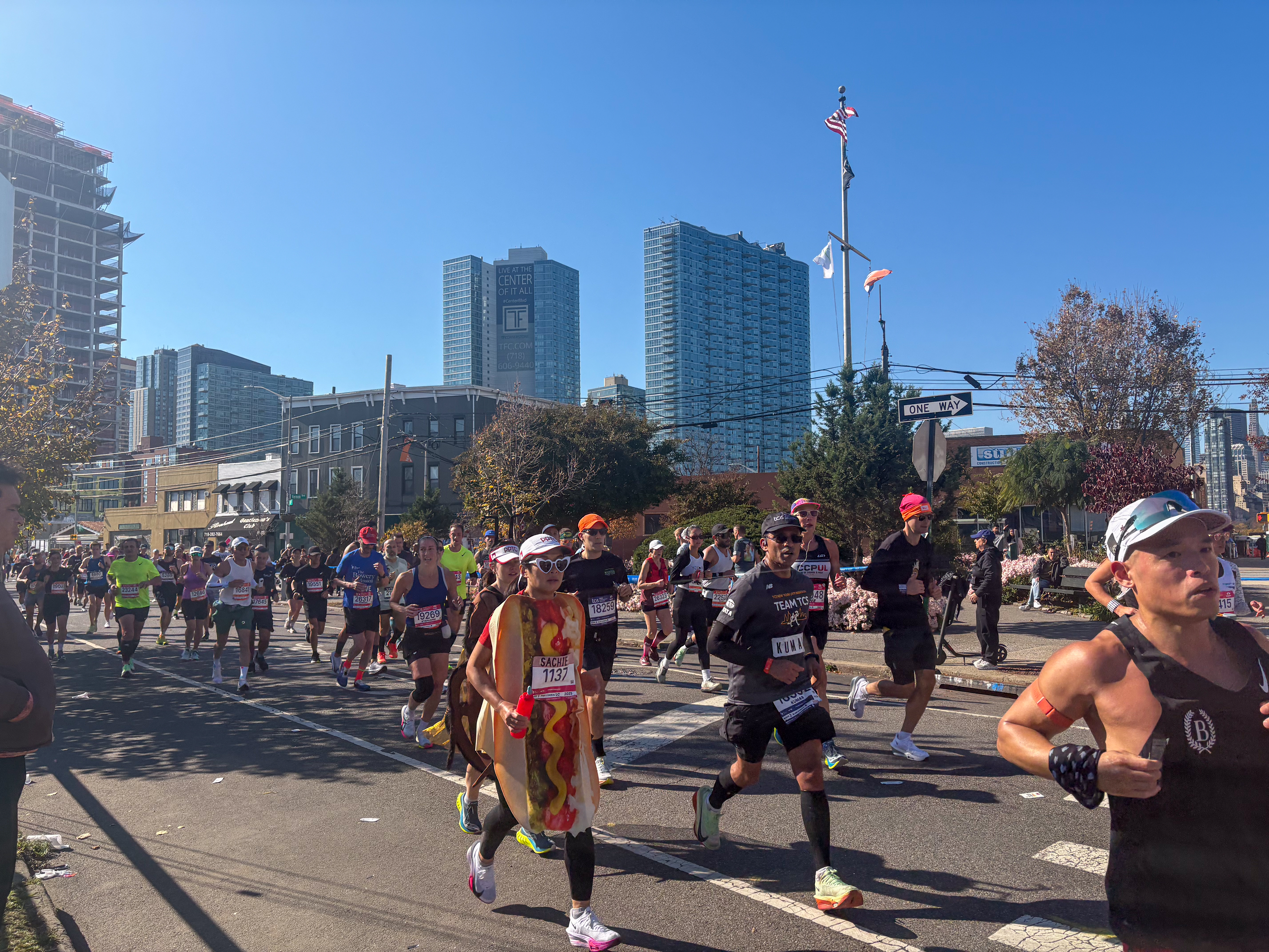 Marathoners turning around a corner — some dressed in costume — at the NYC Marathon in Long Island City.