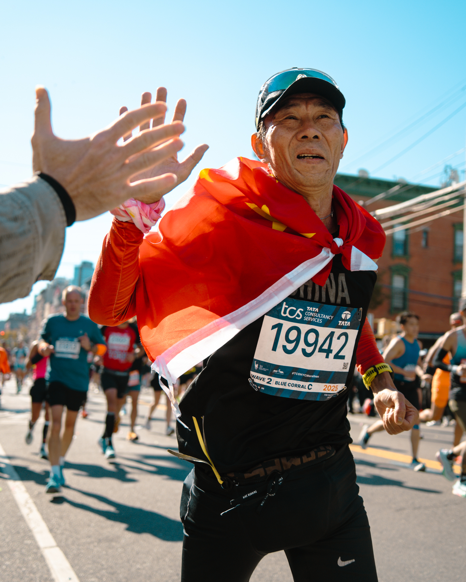 A marathoner running past Mile 13.5 at Vernon Boulevard in Long Island City.