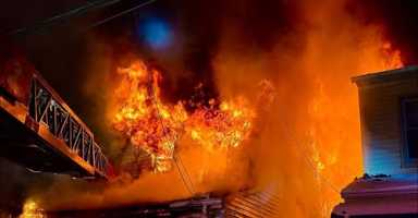 Firefighters battled a two-alarm fire at 70-07 57th Road after the blaze spread to a neighboring home.