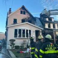 Firefighters battled a three-alarm house fire in Whitestone on Christmas Day that spread to two neighboring homes.