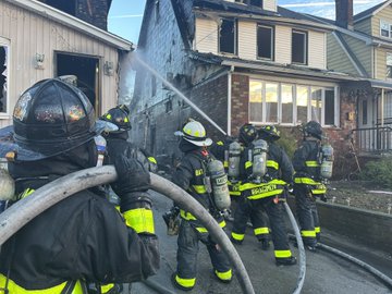Firefighters battled a three-alarm house fire in Whitestone on Christmas Day that spread to two neighboring homes. 