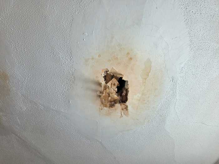 A hole in a bedroom ceiling, allegedly caused by leaking during heavy rainfall. Photo by Shane O'Brien.