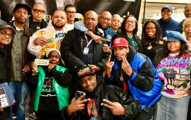 Queens Public Library Hip Hop Coordinator Ralph McFaniels is surrounded by many of the entrepreneurs who made the Jamaica Colosseum Mall a local icon.